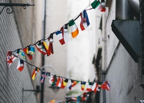 Bandeiras de diferentes países penduradas em iluminação de rua