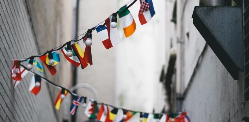Bandeiras de diferentes países penduradas em iluminação de rua